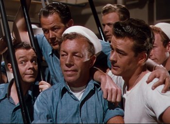 Movie still from “Anchors Aweigh” (1945), directed by Joseph Barbera – A group of men standing next to each other; Medium shot, High angle