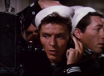 Movie still from “Anchors Aweigh” (1945), directed by Joseph Barbera – A man in a sailor's uniform talking on a phone; Close Up shot, High angle