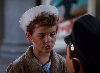 Movie still from “Anchors Aweigh” (1945), directed by Joseph Barbera – A young boy wearing a sailor's hat in front of an older man; Close Up shot, Over the shoulder angle