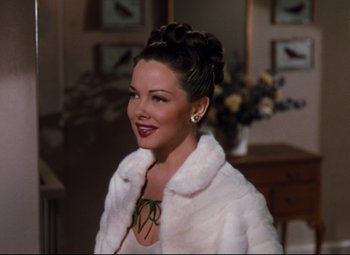 Movie still from “Anchors Aweigh” (1945), directed by Joseph Barbera – A woman in a white fur coat smiling for the camera; Close Up shot, High angle