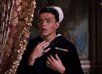Movie still from “Anchors Aweigh” (1945), directed by Joseph Barbera – A man in a sailor's uniform holding a bag in front of a mirror; Close Up shot, Low angle