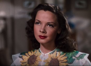 Movie still from “Anchors Aweigh” (1945), directed by Joseph Barbera – A beautiful woman with long dark hair wearing a sunflower shirt; Close Up shot, High angle