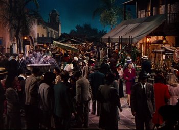 Movie still from “Anchors Aweigh” (1945), directed by Joseph Barbera – A group of people standing on a street at night; Extreme Wide shot, High angle