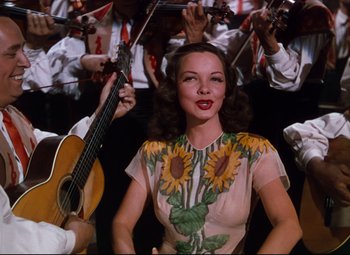 Movie still from “Anchors Aweigh” (1945), directed by Joseph Barbera – A woman in a dress with sunflowers on it; Medium shot, Low angle