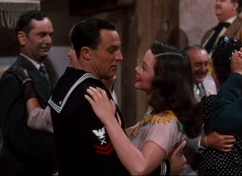Movie still from “Anchors Aweigh” (1945), directed by Joseph Barbera – A man and a woman are dancing in front of a crowd; Medium shot, Over the shoulder angle