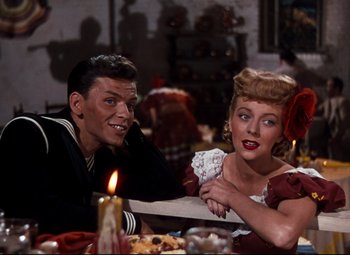 Movie still from “Anchors Aweigh” (1945), directed by Joseph Barbera – A man and a woman sitting at a dinner table; Medium shot, High angle