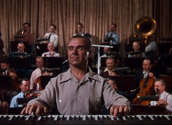 Movie still from “Anchors Aweigh” (1945), directed by Joseph Barbera – A man sitting in front of a piano in front of an orchestra; Medium shot, Low angle