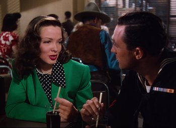 Movie still from “Anchors Aweigh” (1945), directed by Joseph Barbera – A man and a woman sitting at a table talking to each other; Medium shot, Over the shoulder angle