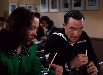 Movie still from “Anchors Aweigh” (1945), directed by Joseph Barbera – A man and a woman sitting at a table with chopsticks in their hands; Medium shot, Over the shoulder angle