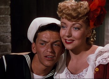 Movie still from “Anchors Aweigh” (1945), directed by Joseph Barbera – A man and a woman posing for a picture; Close Up shot, Low angle