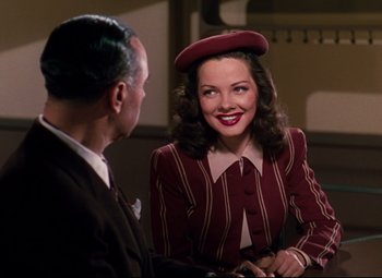 Movie still from “Anchors Aweigh” (1945), directed by Joseph Barbera – A woman wearing a hat talking to an older man; Medium shot, Over the shoulder angle