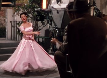 Movie still from “Anchors Aweigh” (1945), directed by Joseph Barbera – A woman in a pink dress and a man in a suit; Wide shot, Low angle