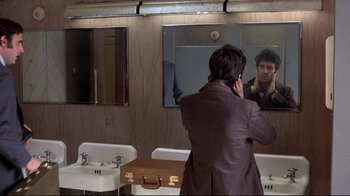 Movie still from “And Justice for All” (1979), directed by Norman Jewison – A man standing in front of a bathroom mirror; Close Up shot, Over the shoulder angle