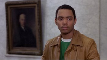 Movie still from “And Justice for All” (1979), directed by Norman Jewison – A man in a green shirt and a brown leather jacket; Close Up shot, Over the shoulder angle