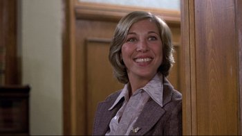 Movie still from “And Justice for All” (1979), directed by Norman Jewison – A woman smiling for the camera while wearing a suit; Close Up shot, Low angle