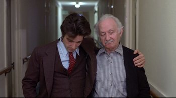 Movie still from “And Justice for All” (1979), directed by Norman Jewison – A man and an older man standing next to each other; Medium shot, Low angle