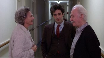 Movie still from “And Justice for All” (1979), directed by Norman Jewison – Two men and a woman standing in a hallway talking; Medium shot, Over the shoulder angle