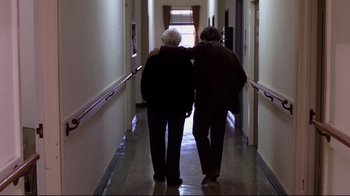 Movie still from “And Justice for All” (1979), directed by Norman Jewison – Two older people walking down a long hallway together; Wide shot, Low angle
