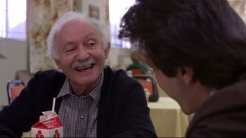 Movie still from “And Justice for All” (1979), directed by Norman Jewison – An older man and a younger man are smiling; Close Up shot, Over the shoulder angle