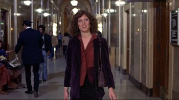 Movie still from “And Justice for All” (1979), directed by Norman Jewison – A woman walking down a hallway in a building; Wide shot, Over the shoulder angle
