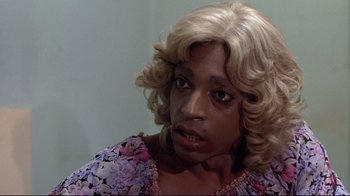 Movie still from “And Justice for All” (1979), directed by Norman Jewison – A woman with blonde hair wearing a wig; Close Up shot, Over the shoulder angle