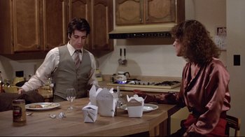 Movie still from “And Justice for All” (1979), directed by Norman Jewison – A man and a woman sitting at a dinner table; Medium shot, Over the shoulder angle