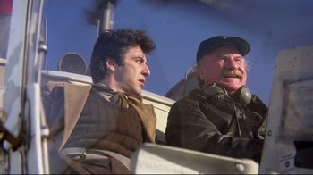 Movie still from “And Justice for All” (1979), directed by Norman Jewison – A man and a man sitting next to each other on a boat; Medium shot, Low angle