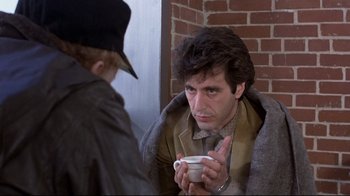 Movie still from “And Justice for All” (1979), directed by Norman Jewison – A man sitting on a couch holding a cup of coffee; Close Up shot, Over the shoulder angle