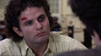 Movie still from “And Justice for All” (1979), directed by Norman Jewison – A man with a bandage on his head and face; Close Up shot, Over the shoulder angle