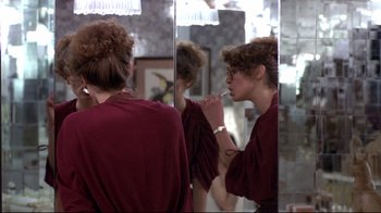 Movie still from “And Justice for All” (1979), directed by Norman Jewison – A woman brushing her teeth in the mirror; Medium shot, Over the shoulder angle