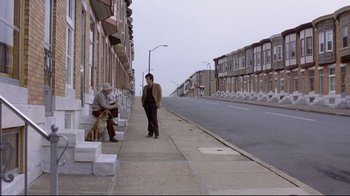 Movie still from “And Justice for All” (1979), directed by Norman Jewison – A man standing on a sidewalk next to a woman and a dog; Wide shot, High angle