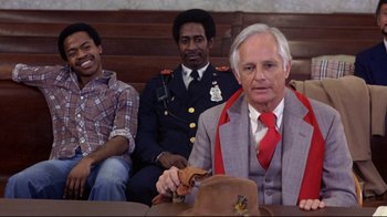 Movie still from “And Justice for All” (1979), directed by Norman Jewison – A man in a red tie sitting next to two other men; Medium shot, Low angle