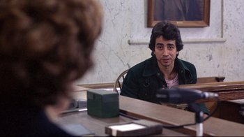 Movie still from “And Justice for All” (1979), directed by Norman Jewison – A man sitting in front of a mirror in front of a table; Medium shot, Over the shoulder angle