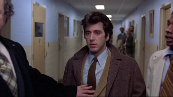 Movie still from “And Justice for All” (1979), directed by Norman Jewison – A man wearing a suit and tie standing in a hallway; Close Up shot, Over the shoulder angle