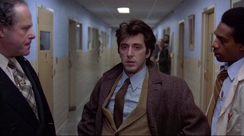 Movie still from “And Justice for All” (1979), directed by Norman Jewison – A man wearing a suit and tie in a hallway; Medium shot, Low angle