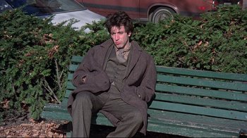 Movie still from “And Justice for All” (1979), directed by Norman Jewison – A man sitting on top of a wooden park bench; Medium shot, High angle