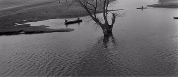 Movie still from “Andrei Rublev” (1966), directed by Andrei Tarkovsky – Two people in a boat in a body of water; Extreme Wide shot, High angle