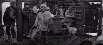 Movie still from “Andrei Rublev” (1966), directed by Andrei Tarkovsky – A group of men standing next to each other near a dog; Wide shot, High angle