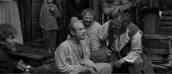 Movie still from “Andrei Rublev” (1966), directed by Andrei Tarkovsky – A black and white photo of a group of people; Medium shot, High angle