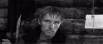Movie still from “Andrei Rublev” (1966), directed by Andrei Tarkovsky – Black and white photograph of a man looking at the camera; Close Up shot, Low angle