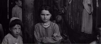 Movie still from “Andrei Rublev” (1966), directed by Andrei Tarkovsky – A young girl standing in front of an older man; Medium shot, High angle