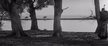 Movie still from “Andrei Rublev” (1966), directed by Andrei Tarkovsky – A person on a horse is riding by the water; Extreme Wide shot, High angle
