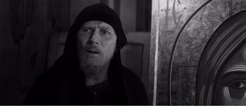 Movie still from “Andrei Rublev” (1966), directed by Andrei Tarkovsky – An old man wearing a black hood looking at the camera; Close Up shot, Over the shoulder angle