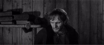 Movie still from “Andrei Rublev” (1966), directed by Andrei Tarkovsky – A black and white photo of a man with a beard; Close Up shot, Over the shoulder angle