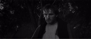 Movie still from “Andrei Rublev” (1966), directed by Andrei Tarkovsky – Black and white photograph of a man in front of a tree; Close Up shot, High angle