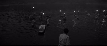 Movie still from “Andrei Rublev” (1966), directed by Andrei Tarkovsky – A black and white photo of people in a body of water; Extreme Wide shot, High angle