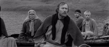 Movie still from “Andrei Rublev” (1966), directed by Andrei Tarkovsky – A group of people standing next to a body of water; Medium shot, High angle