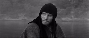 Movie still from “Andrei Rublev” (1966), directed by Andrei Tarkovsky – Black and white photograph of a man wearing a hood; Close Up shot, High angle