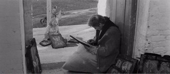 Movie still from “Andrei Rublev” (1966), directed by Andrei Tarkovsky – An older woman sitting on the steps of a house; Medium shot, High angle