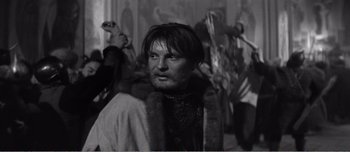 Movie still from “Andrei Rublev” (1966), directed by Andrei Tarkovsky – A black and white photo of a man in a fur coat; Close Up shot, Low angle